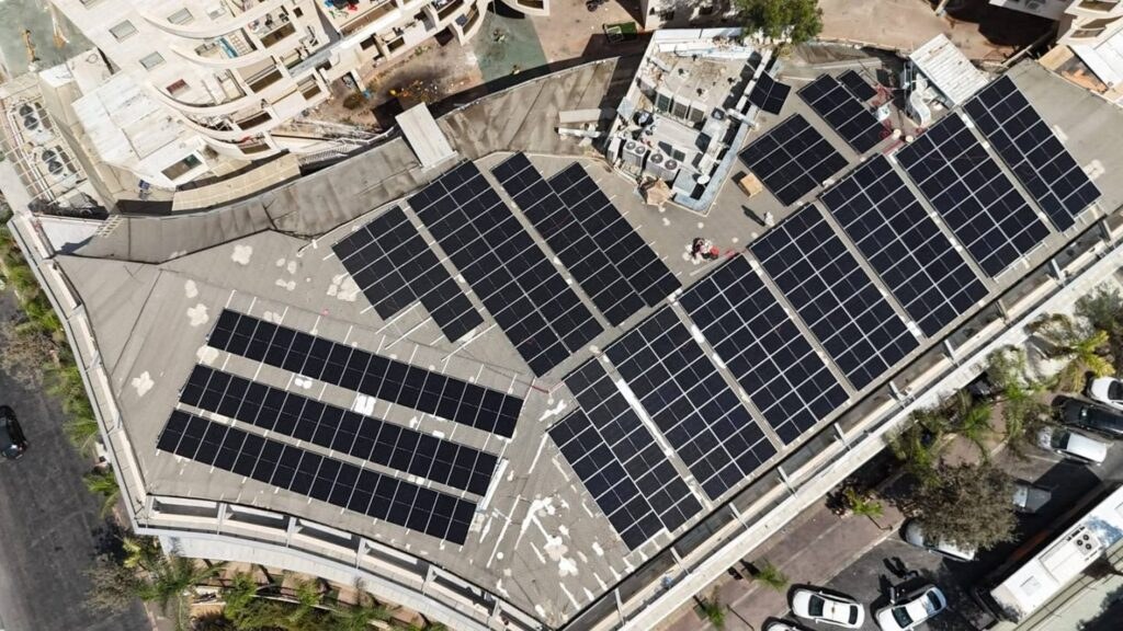 Solar panels on a commercial building roof, aerial view of a commercial solar system